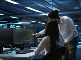 Dua teknisi IT sedang memantau sistem jaringan dan keamanan server infrastruktur IT bisnis di ruang data center