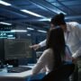 Dua teknisi IT sedang memantau sistem jaringan dan keamanan server infrastruktur IT bisnis di ruang data center