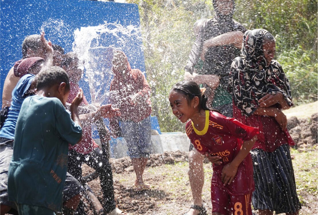 Anak-anak dan warga Desa Ajaobaki gembira bermain cipratan air bersih yang mengalir dari jaringan pipa HDPE Vinilon Group dan Solar Chapter di Timor Tengah Selatan NTT.