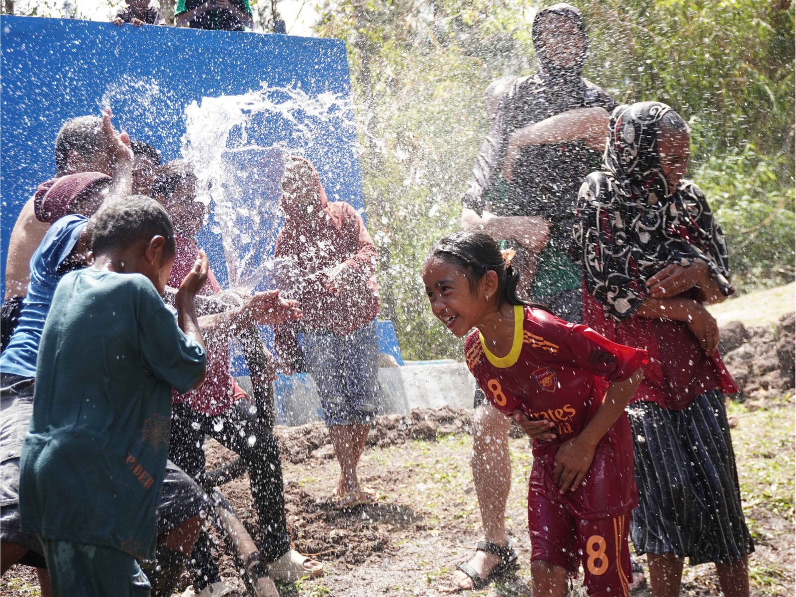 Anak-anak dan warga Desa Ajaobaki gembira bermain cipratan air bersih yang mengalir dari jaringan pipa HDPE Vinilon Group dan Solar Chapter di Timor Tengah Selatan NTT.